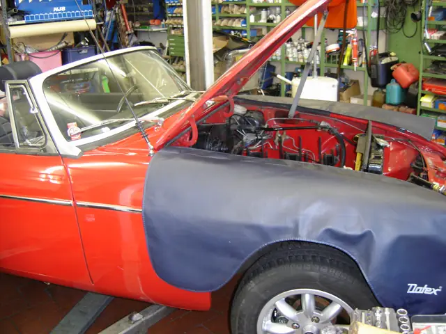 Rotes Cabrio mit Kotflügelschoner in der Werkstatt