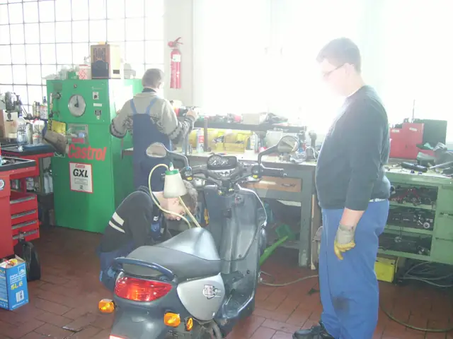 Werkstatt mit Motorroller und Mitarbeiter