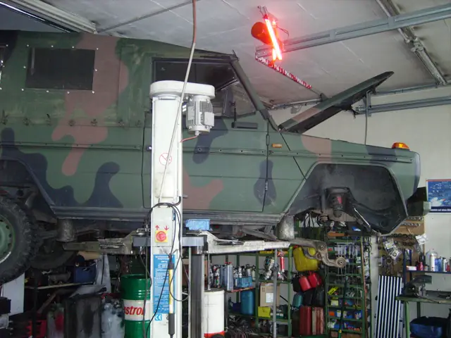 Geländewagen in Tarnlackierung auf der Hebebühne