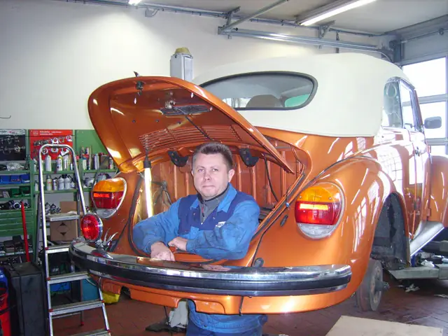 VW Käfer mit Mitarbeiter im Kofferraum